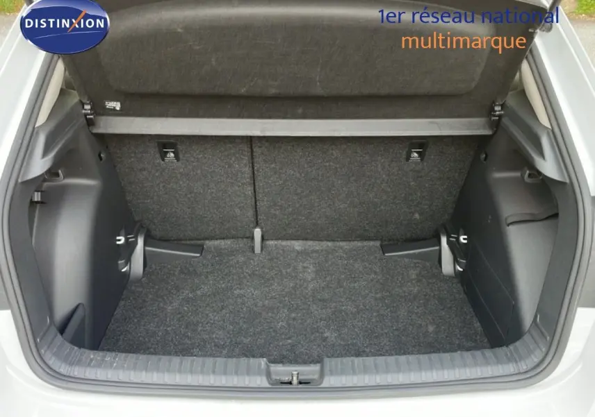 Coffre ouvert d'une Skoda Fabia blanc glacier, vue arrière montrant l'espace de chargement et la moquette grise.