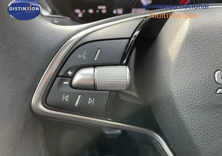 Gros plan sur les commandes audio au volant d'une Skoda Fabia blanche glacier, version 2025, intérieur noir.