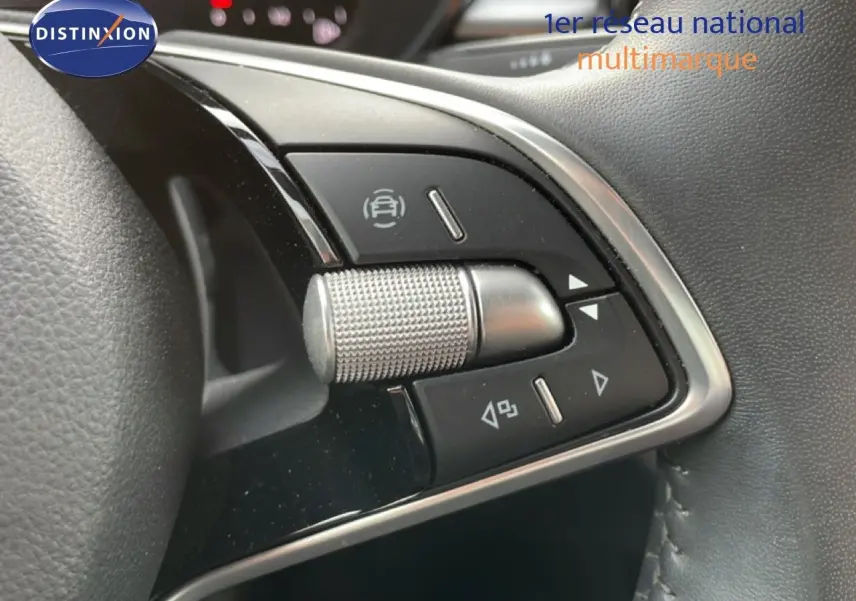 Gros plan sur les commandes multifonctions en aluminium brossé du volant d'une Skoda Fabia 2025, intérieur gris noir.