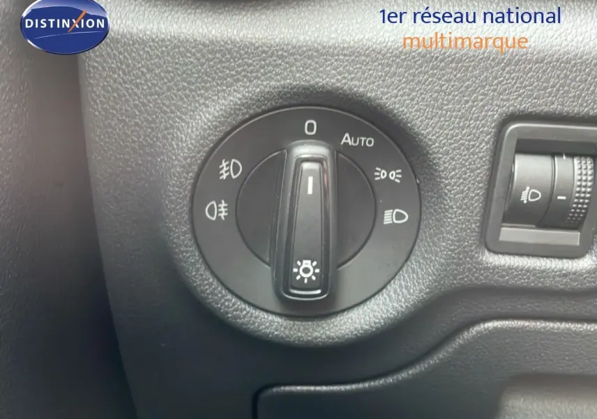 Gros plan sur le bouton de commande des phares dans l’habitacle noir d’une Skoda Fabia blanche Glacier 2025.