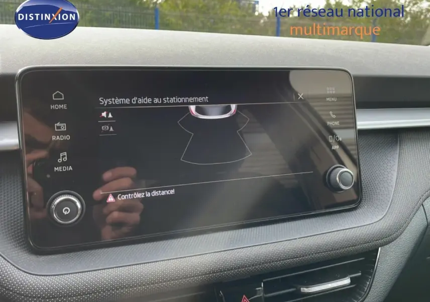 Écran tactile du système d’aide au stationnement dans l’habitacle d’une Skoda Fabia blanc glacier, vue de face.