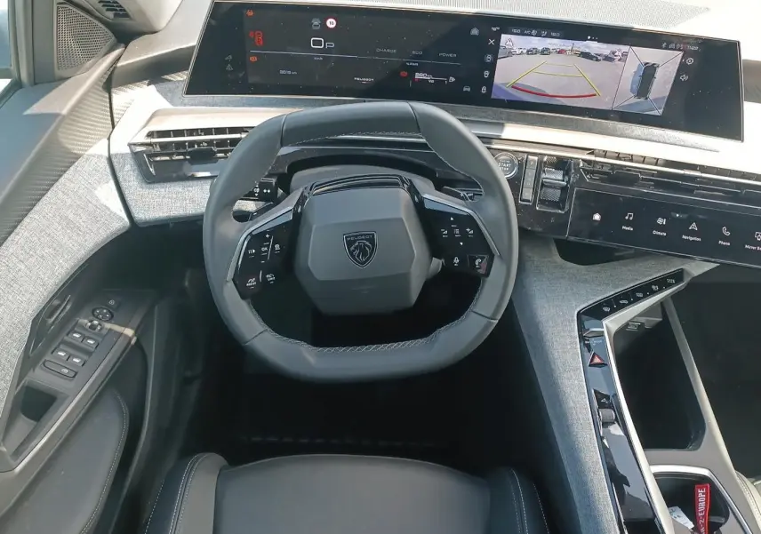 Vue intérieure frontale du poste de conduite du Peugeot 3008 1.2 hybrid 145 allure e-dcs6 avec volant cuir et écran tactile large.