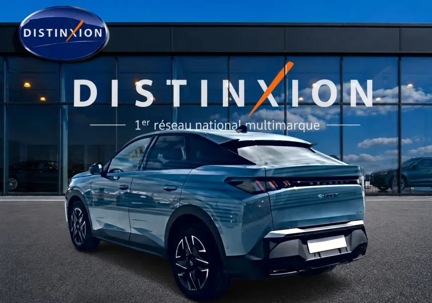 Peugeot 3008 bleu vue 3/4 arrière droit, avec jantes alu et becquet arrière, devant une vitrine Distinxion.