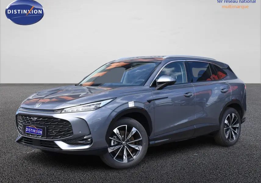 MG Motor EHS gris en 3/4 avant droit, avec jantes alliage noires et phares LED fins, sur fond neutre.