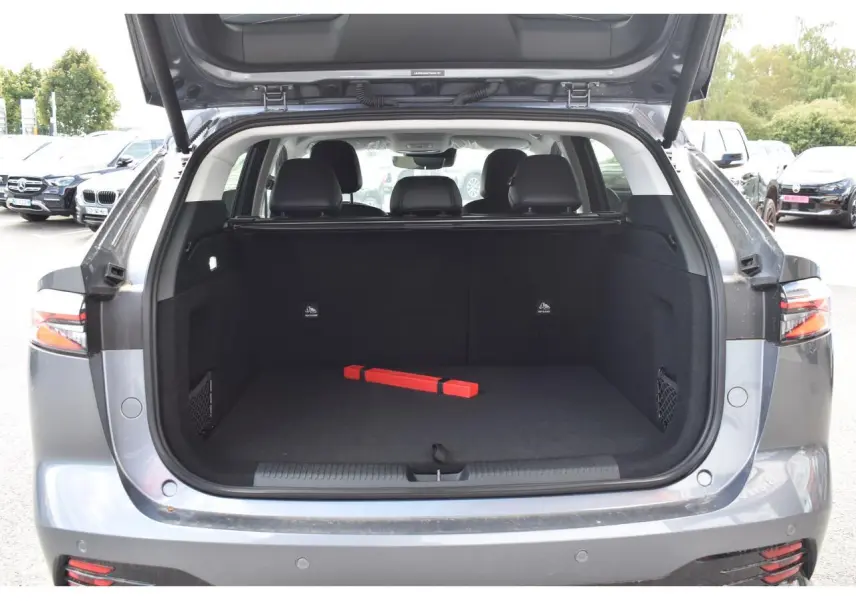 Coffre ouvert vue arrière du MG Motor EHS gris 2026, montrant un espace de chargement vide avec triangle de sécurité rouge.