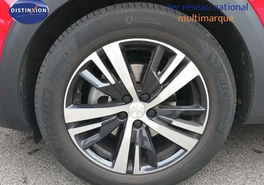 Gros plan sur la jante alliage bicolore du côté gauche d'un Peugeot 3008 rouge foncé métallisé de 2020.