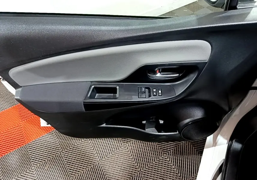 Vue rapprochée de la porte avant gauche blanche de la Toyota Yaris 2019, avec commandes électriques et haut-parleur intégré.