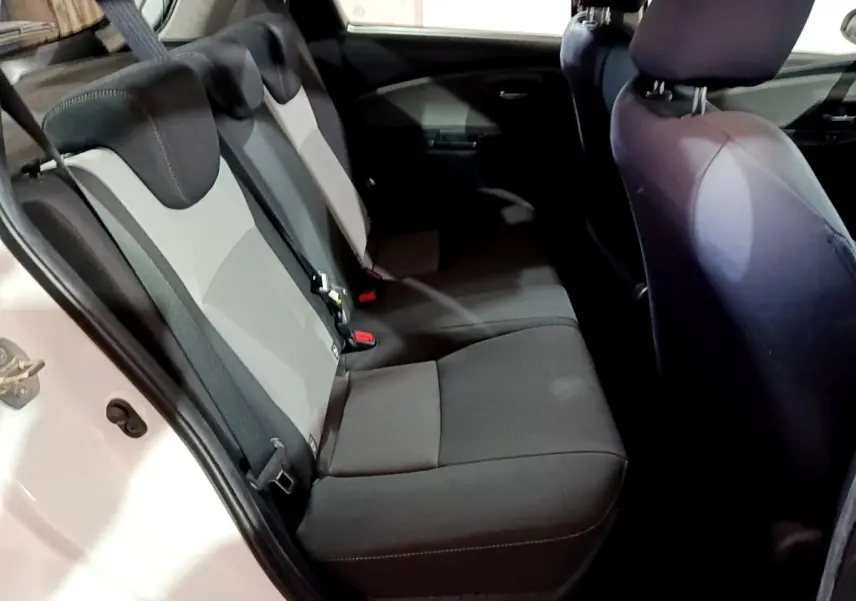 Vue intérieure côté gauche des sièges arrière gris et noirs d'une Toyota Yaris blanche 2019, version hybride.