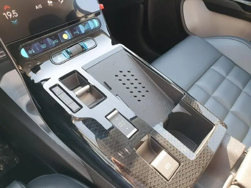 Gros plan sur la console centrale noire brillante et les sièges en cuir bleu du Citroën C5 Aircross hybride 2026.