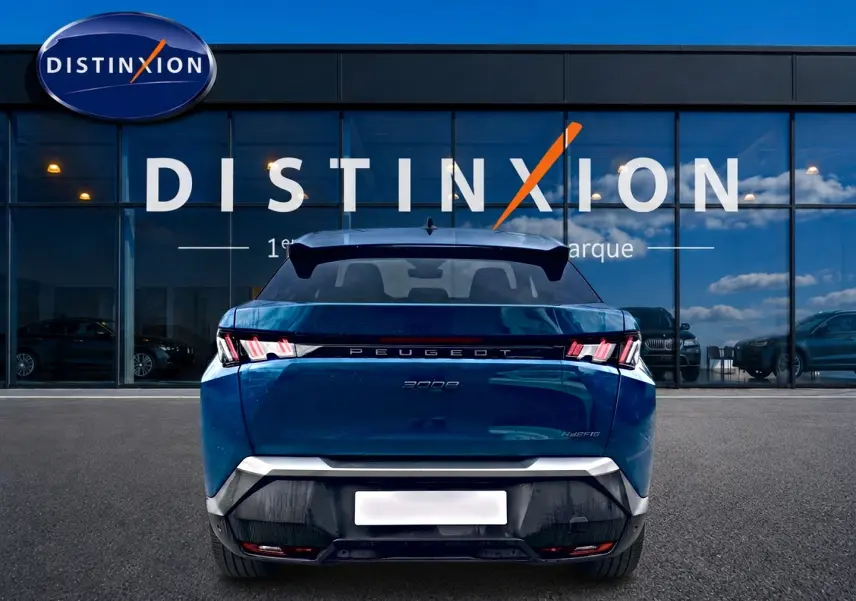 Vue arrière d'un Peugeot 3008 bleu 2025 avec feux arrière LED et becquet noir, devant une vitrine Distinxion.