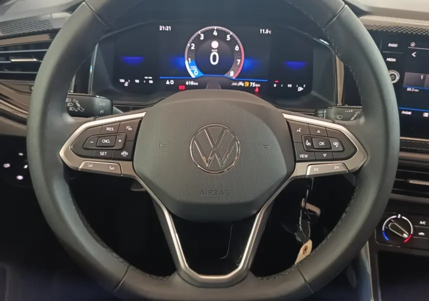 Vue rapprochée du volant multifonctions noir et cuir d'une Volkswagen Polo 2025 avec tableau de bord numérique.