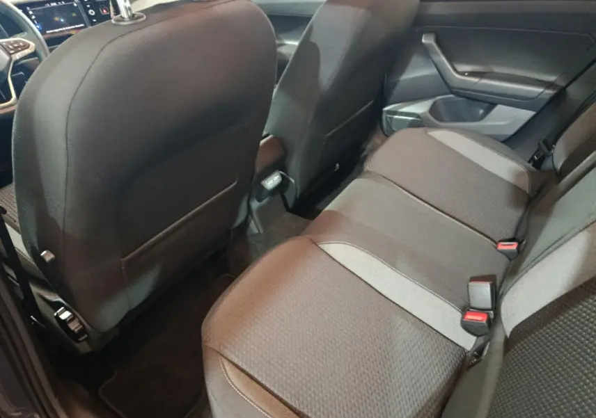 Vue intérieure arrière droite montrant la banquette et le dos des sièges avant de la Volkswagen Polo gris foncé.