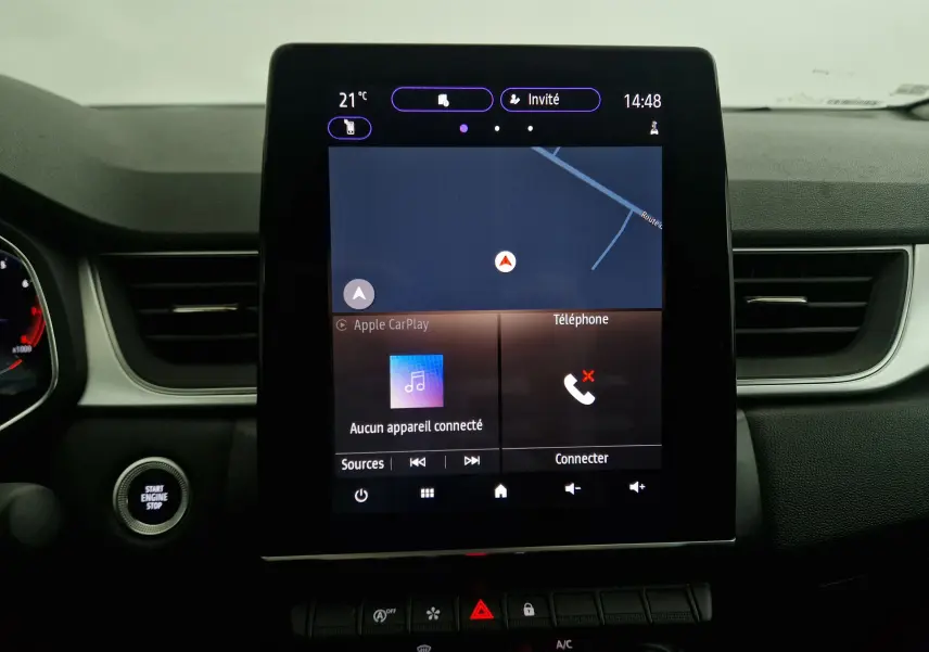 Écran tactile central 7 pouces du Renault Captur 2024 affichant la navigation et Apple CarPlay, entouré du tableau de bord noir.