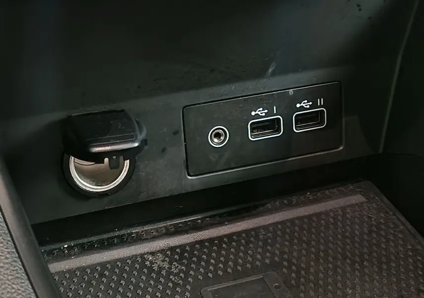 Prise allume-cigare et double port USB intégrés dans la console centrale du Renault Captur 2024 gris Highland/noir.