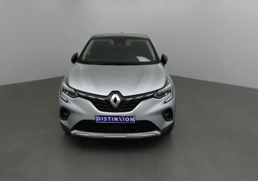 Vue avant d'un Renault Captur 2024 gris Highland avec toit noir et calandre marquée Renault.