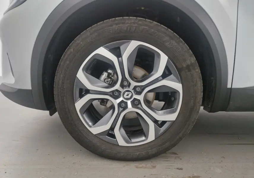 Gros plan sur la roue avant gauche du Renault Captur 2024 gris Highland avec jante alliage 18 pouces au design moderne.