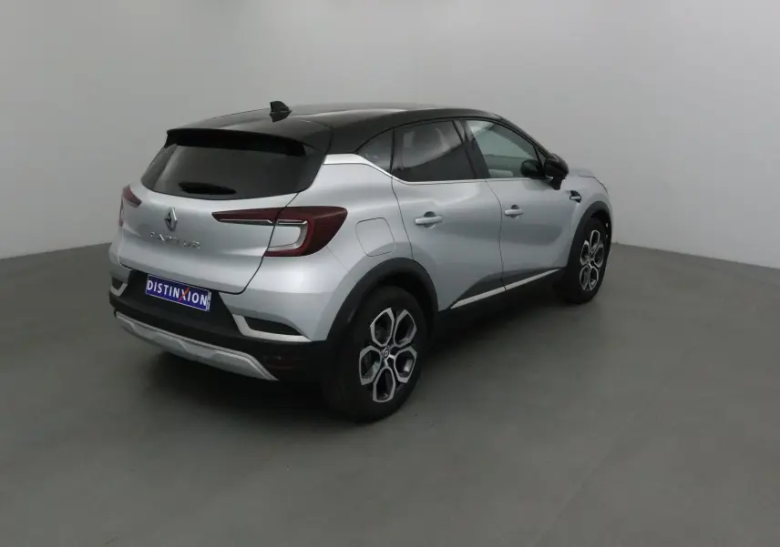 Renault Captur 2024 gris Highland avec toit noir, vu en 3/4 arrière côté droit dans un studio.