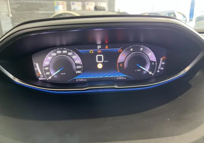 Vue rapprochée du combiné numérique du Peugeot 5008 2024, affichage digital avec éclairage bleu subtil.