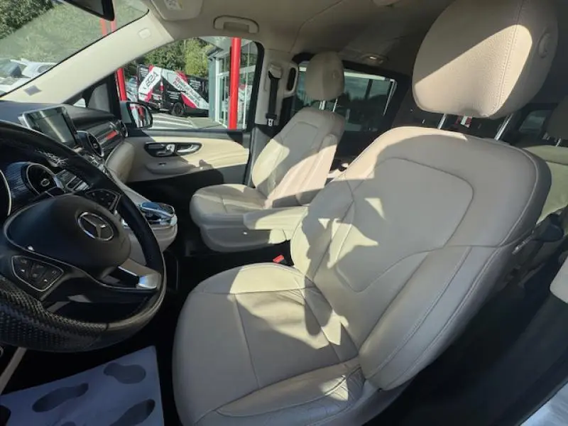 Intérieur clair du Mercedes Classe V 250 d 2019, sièges avant en cuir beige et volant multifonction noir.