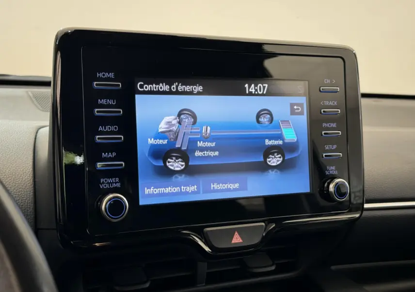 Écran tactile central affichant le contrôle d'énergie hybride dans l'habitacle d'une Toyota Yaris blanche.