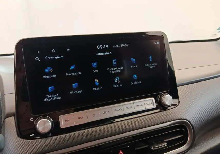Écran tactile central allumé sur tableau de bord gris d’une Hyundai Kona électrique noire, vue intérieure avant.