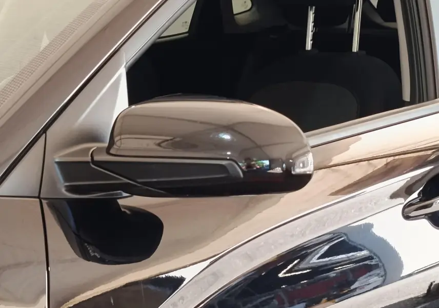 Rétroviseur côté conducteur noir brillant d'une Hyundai Kona électrique 2023, vue rapprochée du côté gauche.