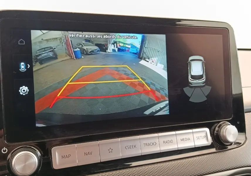 Écran tactile intérieur montrant la caméra de recul et l’aide au stationnement du Hyundai Kona noir électrique 2023.