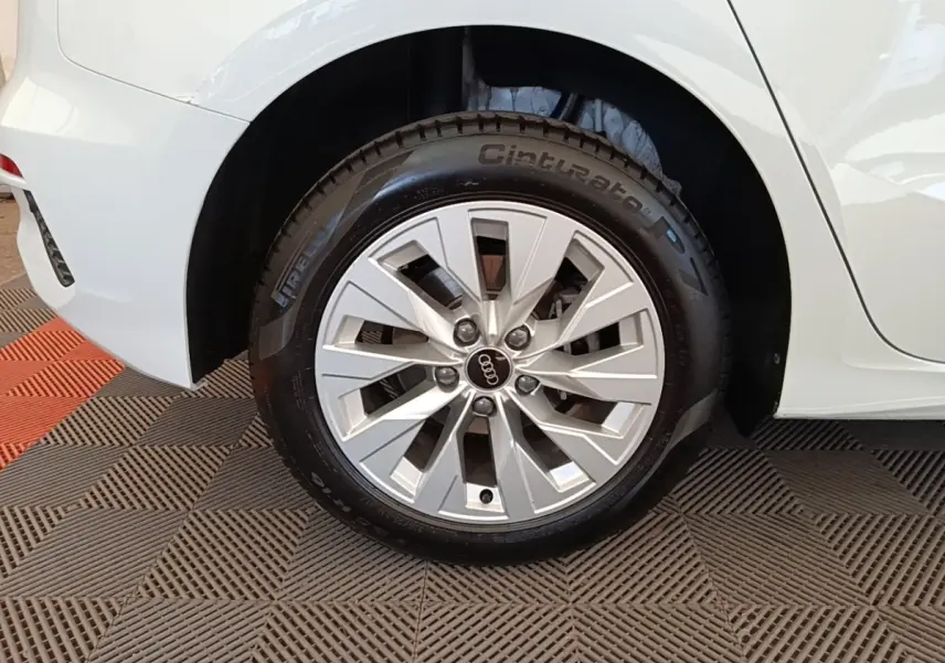 Gros plan sur la roue arrière droite blanche d’une Audi A3 40 TFSI e 204 S Tronic SB avec jante argentée en étoile.