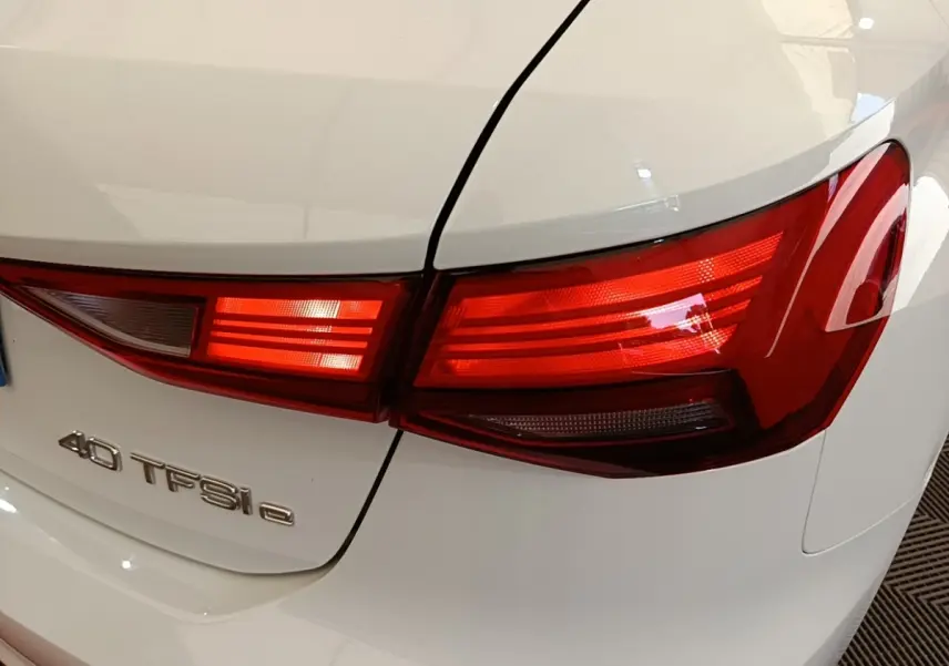 Gros plan sur le feu arrière droit rouge d’une Audi A3 blanche 40 TFSI e avec logo visible sur le coffre.