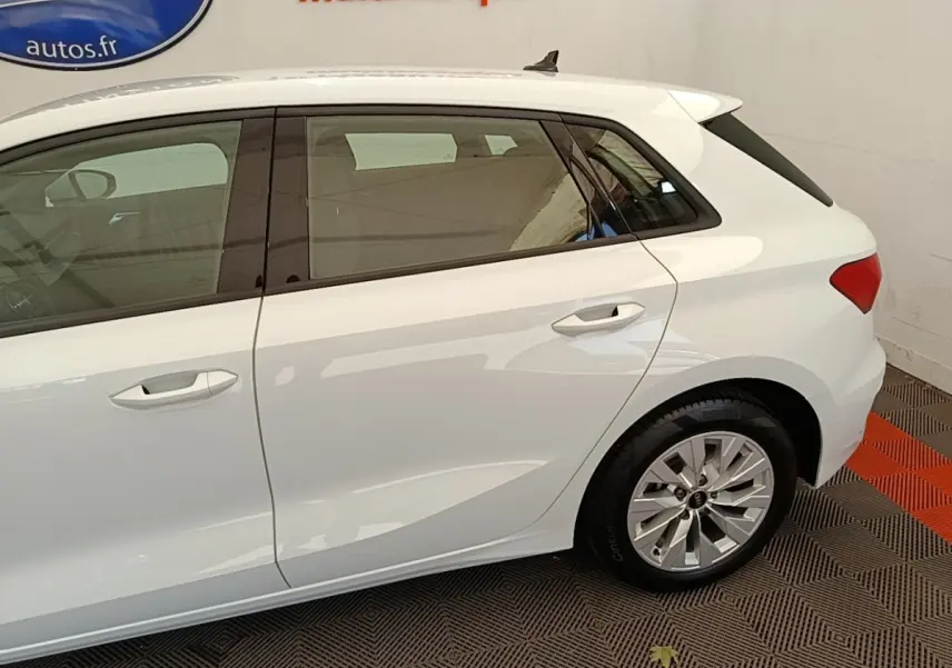 Vue latérale droite d'une Audi A3 blanche hybride rechargeable, mettant en valeur les portes arrière et la jante alliage.