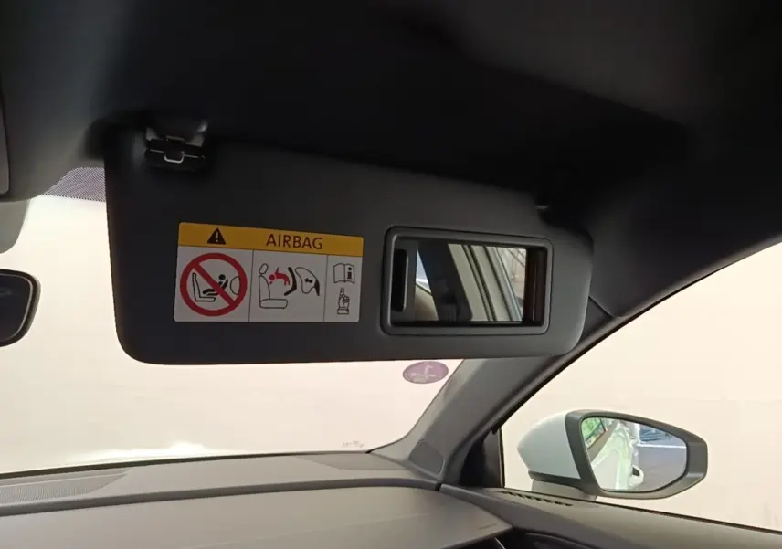 Vue intérieure côté passager de l'Audi A3 blanc, avec pare-soleil et miroir de courtoisie ouvert.