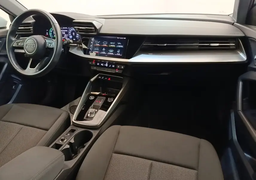 Vue intérieure de l'Audi A3 40 TFSI e 2022, tableau de bord moderne avec écran tactile central et volant cuir noir.