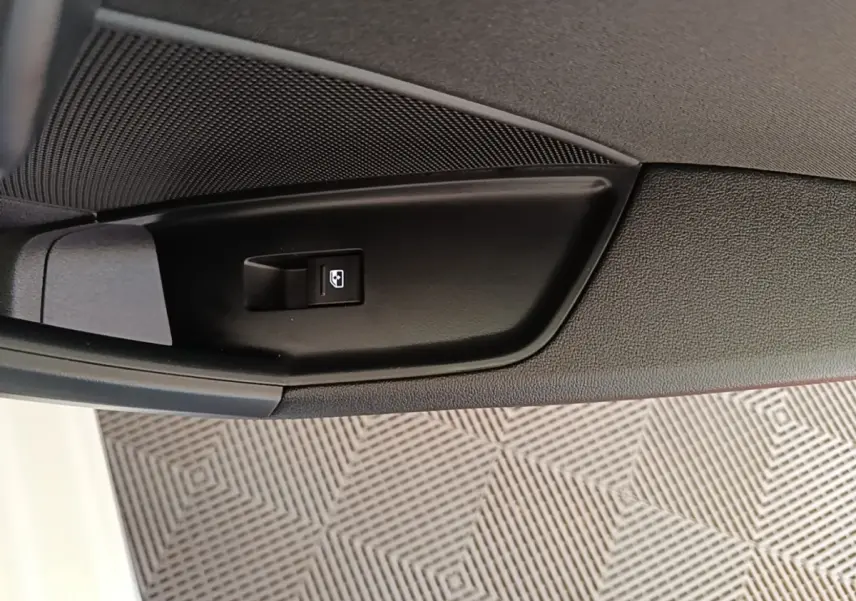 Détail de la commande de lève-vitre électrique côté intérieur d'une Audi A3 blanche hybride rechargeable.