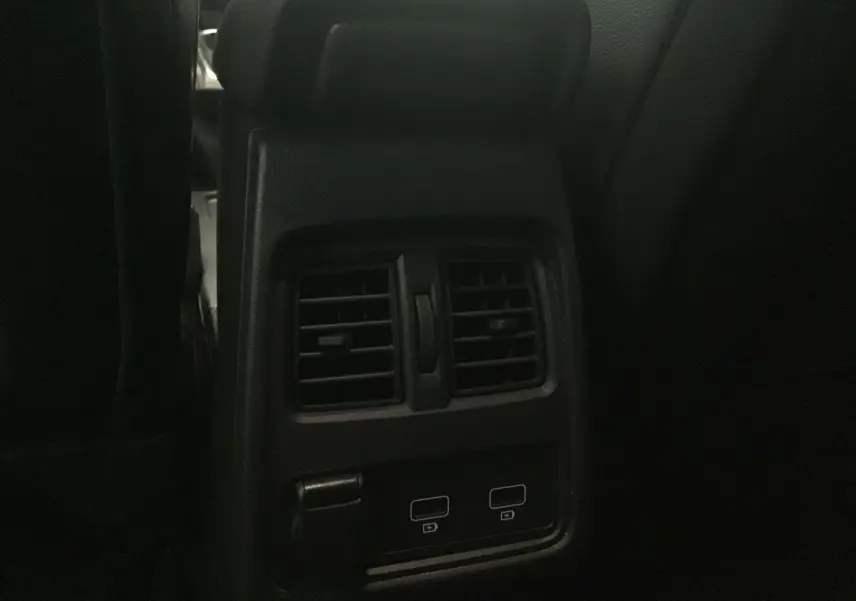 Détail des bouches d'aération arrière et ports USB du Renault Captur blanc nacré/noir, intérieur sombre.