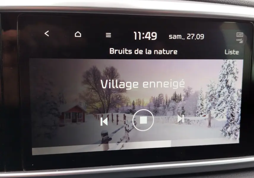 Écran tactile central du Kia Sportage 2022 affichant une ambiance sonore "Village enneigé" dans un cadre intérieur gris.