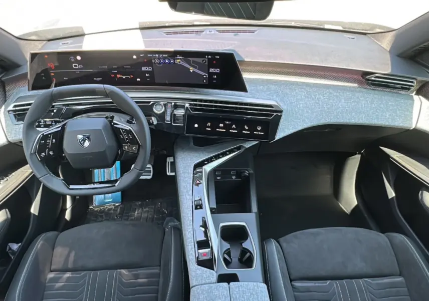 Vue intérieure du tableau de bord et volant du Peugeot 3008 Hybrid 2025 avec finition Alcantara gris et écrans numériques larges.