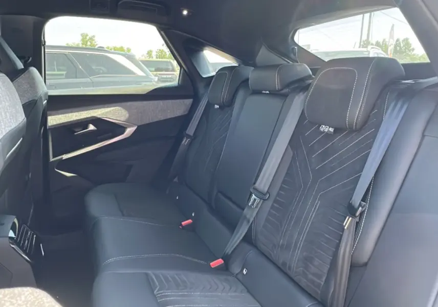 Vue intérieure arrière du Peugeot 3008 Hybrid 145 GT Alcantara 2025 avec sièges noirs en cuir et tissu Alcantara.