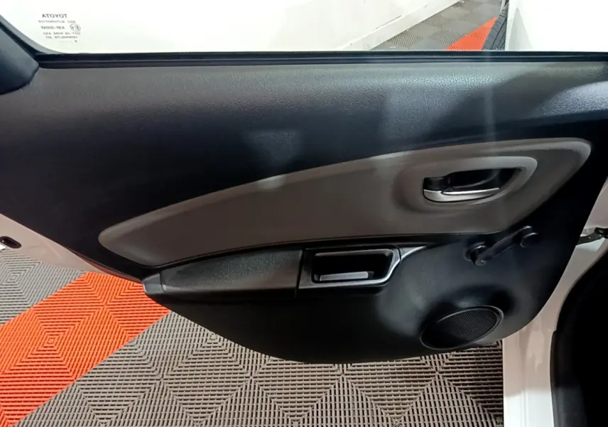 Vue rapprochée de la porte avant gauche blanche de la Toyota Yaris 2019, avec poignée intérieure et haut-parleur intégré.