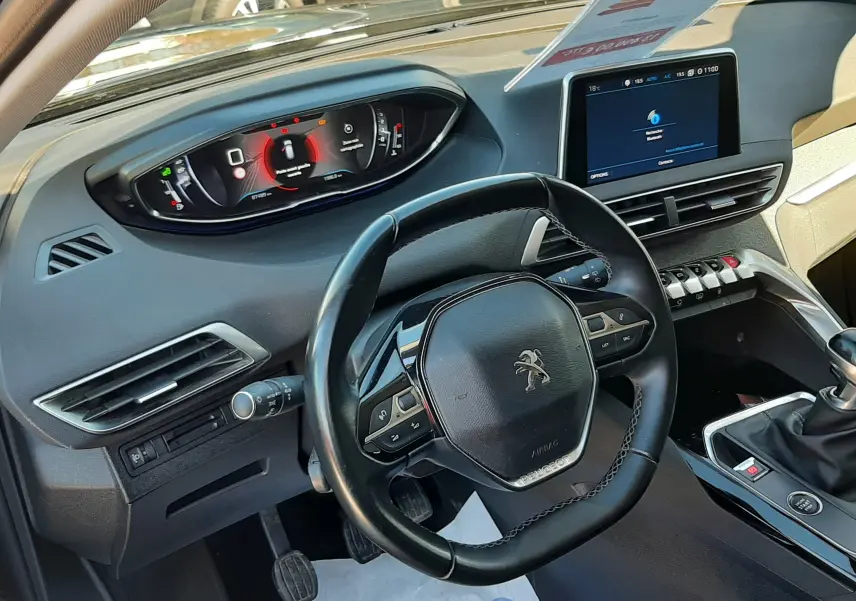 Vue intérieure côté conducteur du Peugeot 3008 noir 2019, mettant en valeur le volant compact et l'écran tactile central.