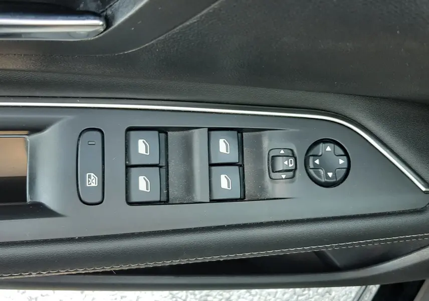 Détail des commandes de lève-vitres et réglages des rétroviseurs côté conducteur d’un Peugeot 3008 noir 2019.
