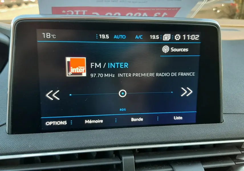 Écran tactile central du Peugeot 3008 noir 2019 affichant la radio FM sur France Inter à 97,7 MHz, avec commande climatisation visible.