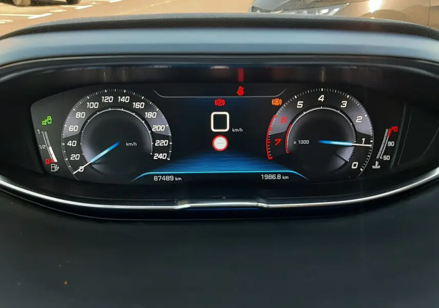 Vue rapprochée du tableau de bord numérique du Peugeot 3008 noir, affichant la vitesse à 0 km/h et le compte-tours.