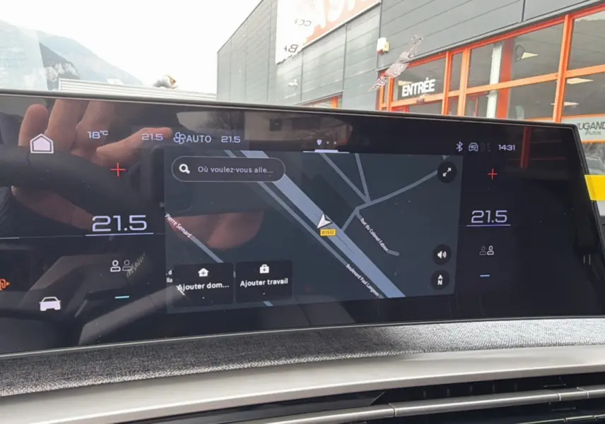 Écran numérique du tableau de bord du Peugeot 3008 Hybrid 145 GT, affichant la navigation et la température intérieure.