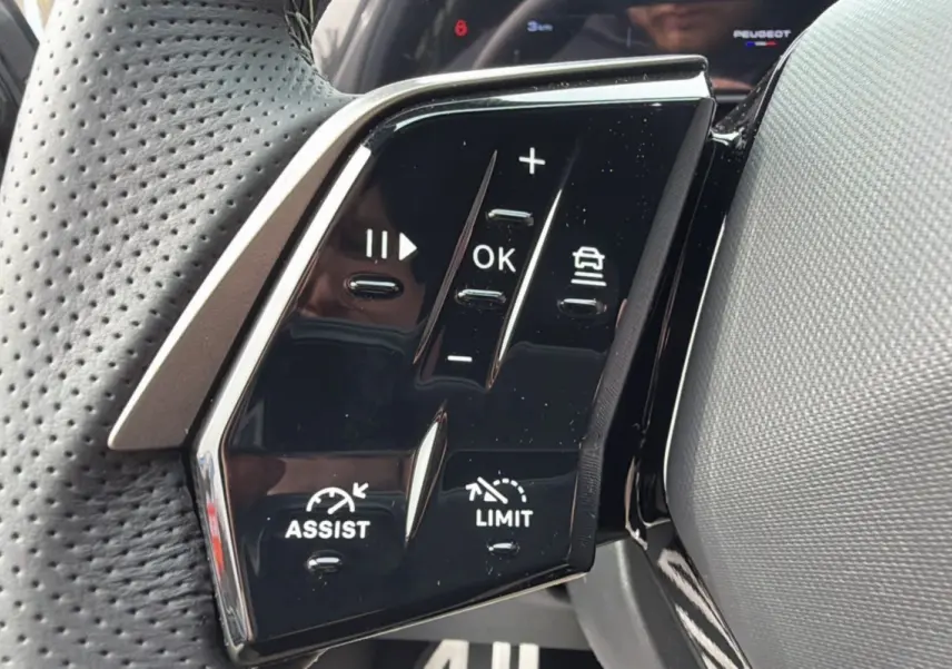 Gros plan sur les commandes multifonctions du volant cuir perforé du Peugeot 3008 Hybrid gris titane.