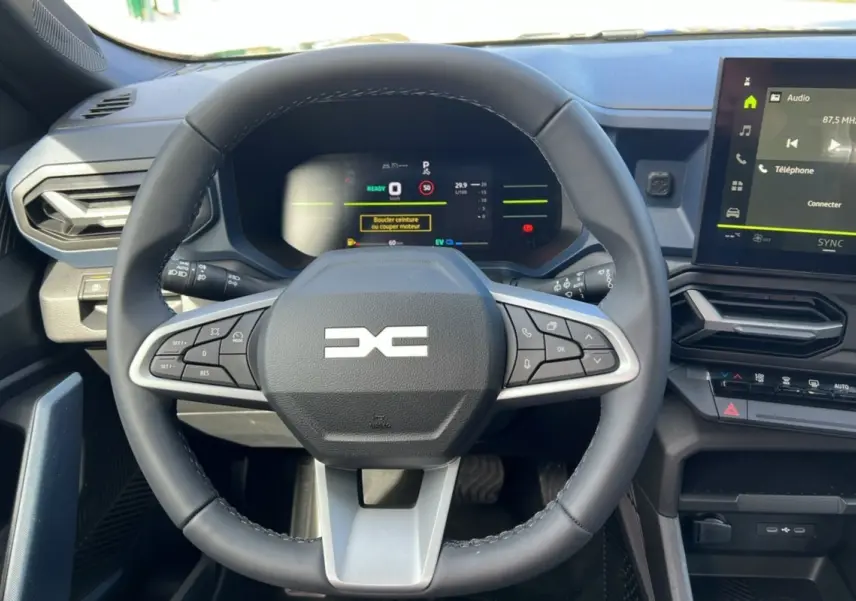 Vue rapprochée du volant cuir et du tableau de bord numérique du Dacia Bigster Hybrid 155 Expression Plus, intérieur moderne.