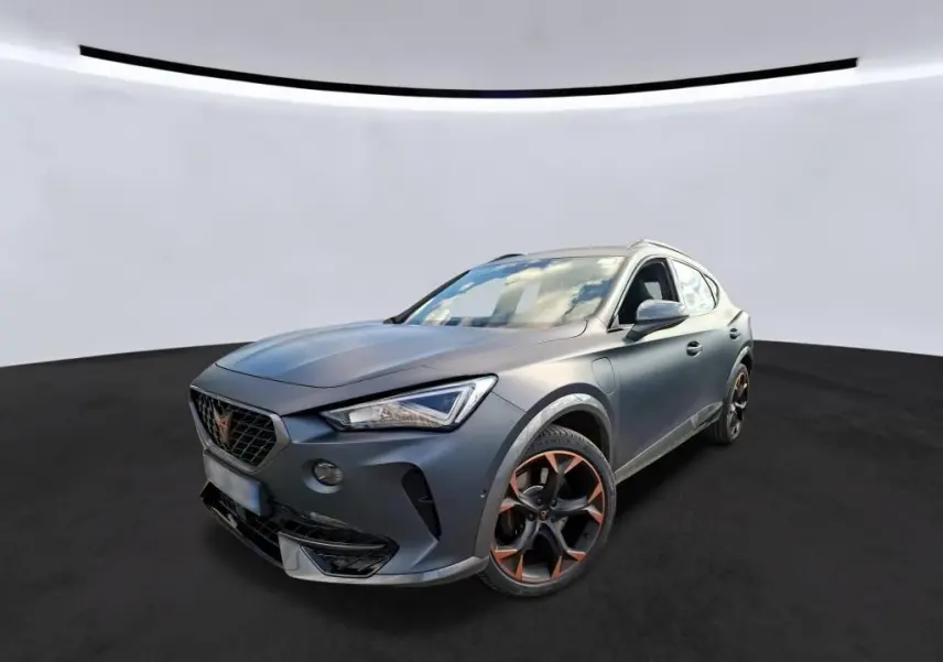 SUV CUPRA Formentor gris foncé mat en 3/4 avant droit, avec jantes noires et détails cuivrés, dans un showroom intérieur.