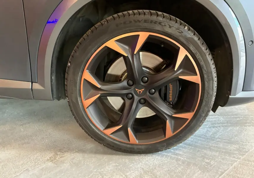 Gros plan sur la roue avant droite d’une CUPRA Formentor gris foncé mat avec jante noire et cuivre, étrier CUPRA visible.