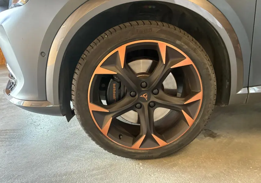 Gros plan sur la roue avant gauche du CUPRA Formentor gris foncé mat, avec jante noire et bronze et étrier de frein marqué CUPRA.