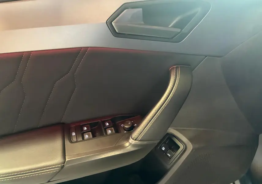 Détail de la porte côté conducteur du CUPRA Formentor gris foncé mat 2024, avec commandes des vitres et rétroviseurs.