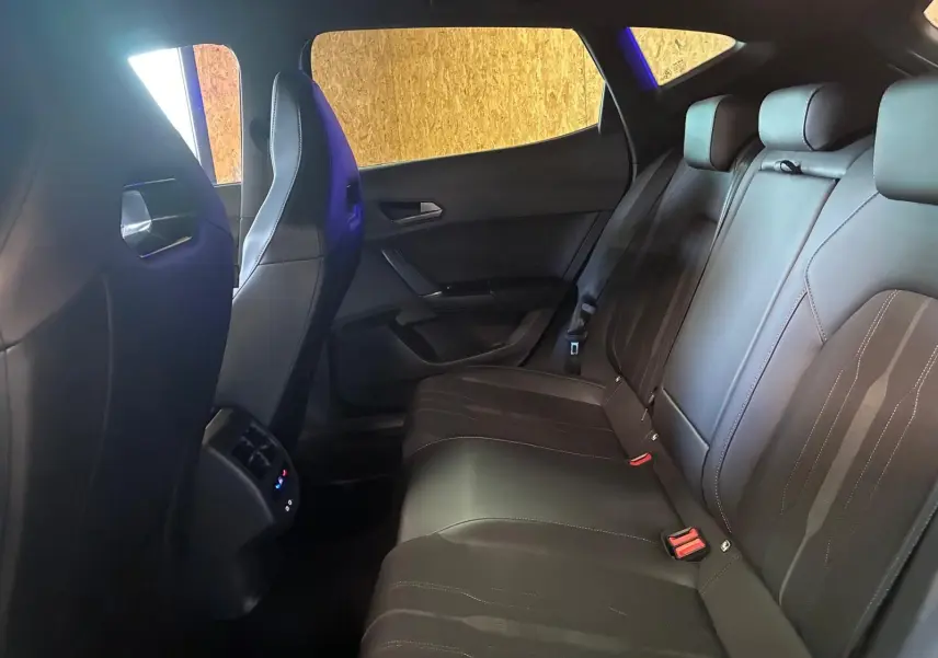 Vue intérieure de la banquette arrière en cuir noir du CUPRA Formentor 1.4 E-HYBRID 2024, avec appuie-têtes et ceintures visibles.